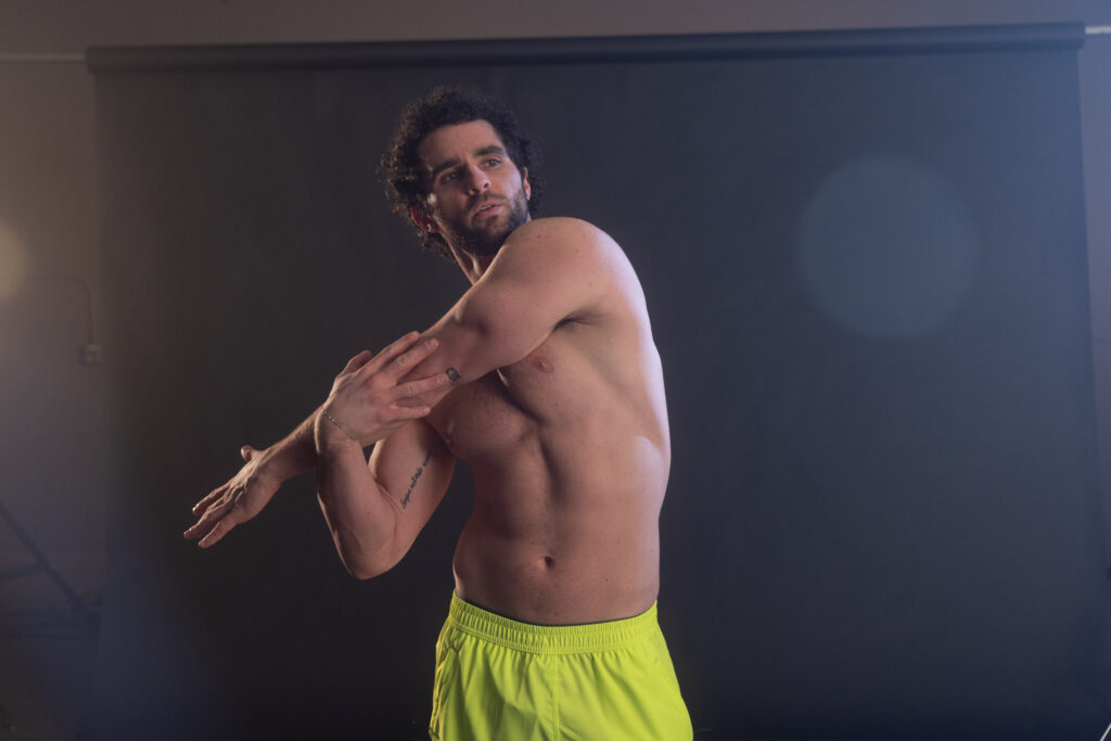 man stretching his arm over his chest