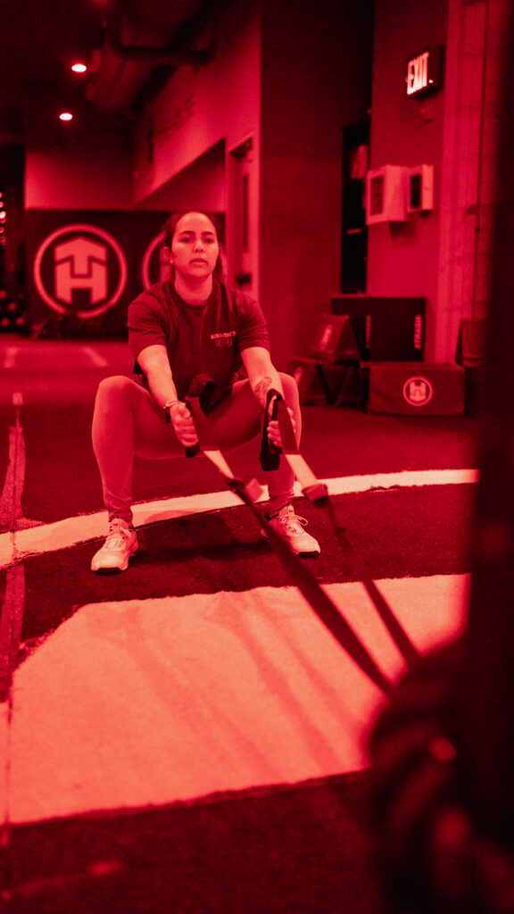 Krysten performing a sled squat and row