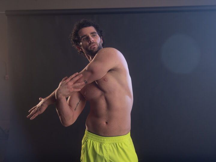 man stretching his arm over his chest