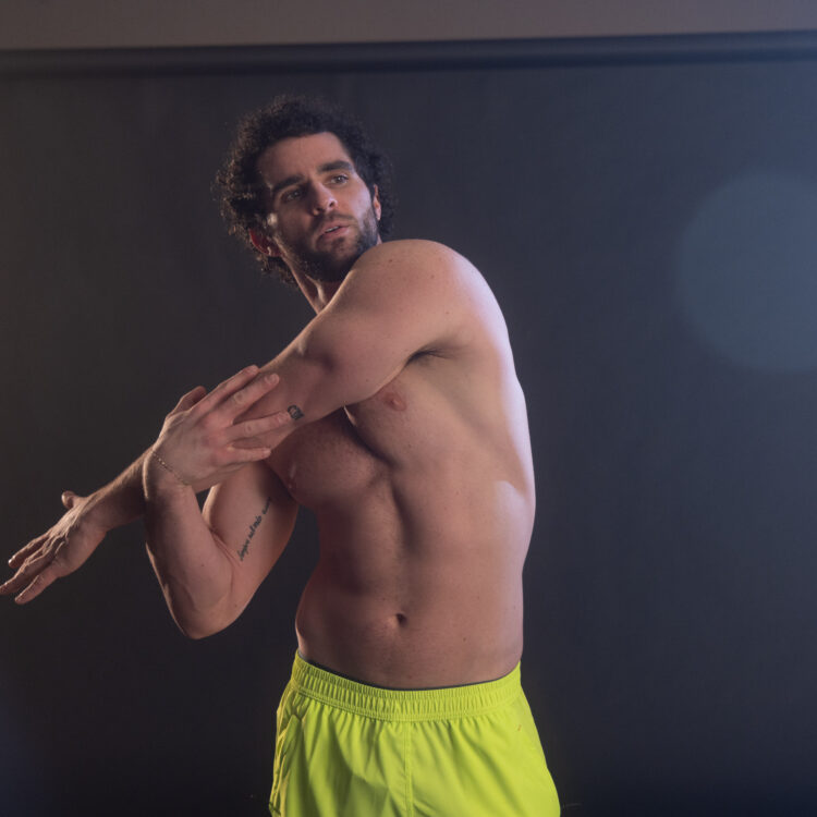 man stretching his arm over his chest